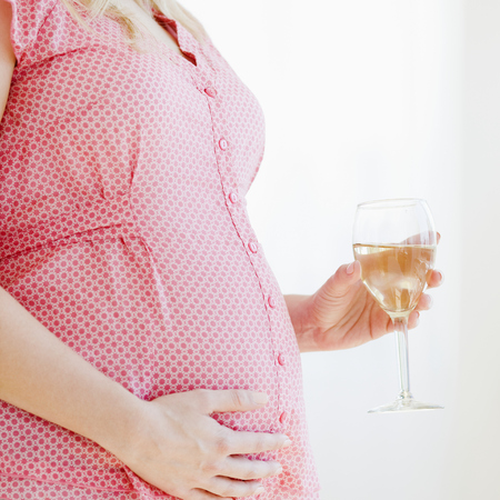 Pregnant woman holding glass of wine