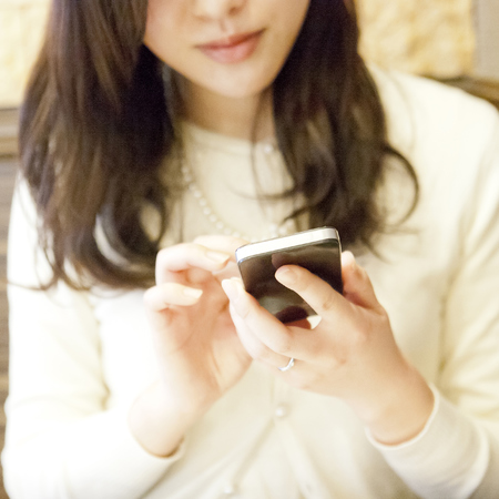 Woman using phone - 5 best multi charger gadgets for your handbag - compact charger for handbag - day bag - handbag.com